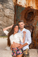 young couple in a beach with shipwreck