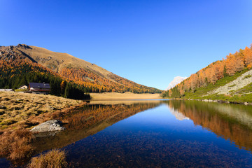 Reflections on water, autumn panorama from mountain lake