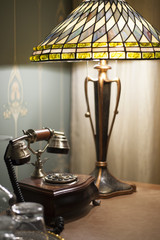 Antique vintage rotary pad telephone and a retro lamp on a table