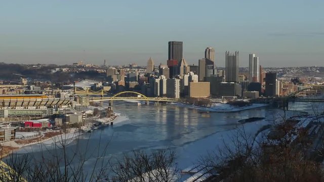 A winter time lapse of the Pittsburgh skyline in the evening as coal barges break through the ice on the surrounding rivers.  	