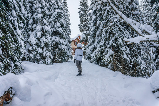 Woman enjoying the wonders of the winter landscape with snow covered trees at Sun Peaks village in the Shuswap Highlands in central British Columbia, Canada