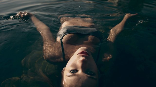 Beautiful model lying on the surface of the sea