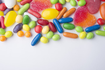 Border of colorful jelly candies on white