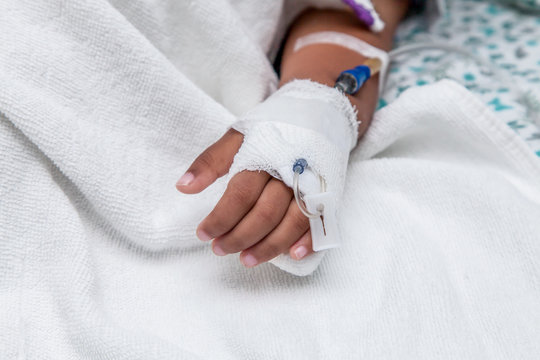 Child's patient hand with saline intravenous (iv) drip 