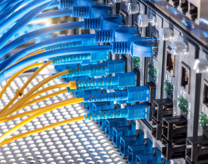 Obraz premium Fiber Optic cables connected to an optic ports and Network cable