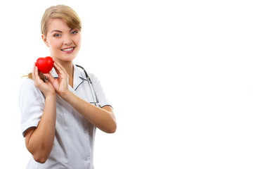 Woman doctor with stethoscope holding red heart, copy space for text, healthcare concept