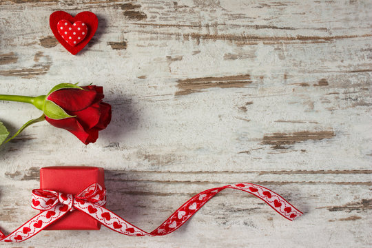 Wrapped gift with ribbon, red heart and rose for Valentines Day, copy space for text