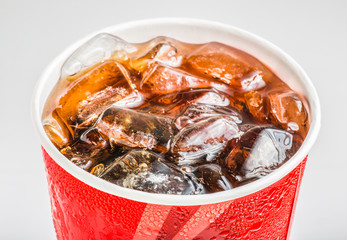 Cola in glass with ice on white background, Close up