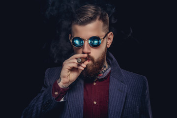 Bearded guy in sunglasses smocking cigar.