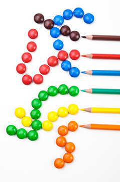 Colorful sweets and pencils isolated on white background.