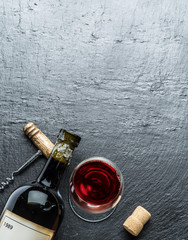 Obraz na płótnie Canvas Wine bottle, wine glass and corkscrew on the graphite board.