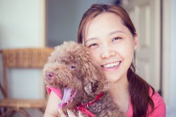 .Asian girl hug with her poodle dog