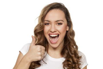 beautiful smiling girl showing thumbs up on a white background