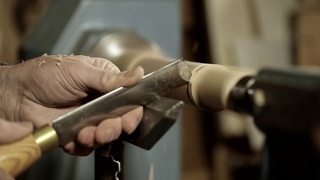 Woodturners using a rotating clamp to turn the wood.