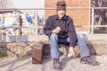 Fototapeta premium tramp eating bread sitting in landfills