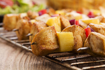 Grilled chicken skewers with pineapple, peppers and onions serve