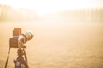 Macchina fotografica  professionale su treppiede in esterno al tramonto 