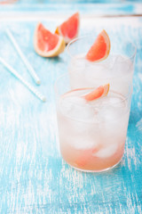 Juicy grapefruit cocktail with ice and alcohol, selective focus.