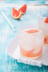Juicy grapefruit cocktail with ice and alcohol, selective focus.