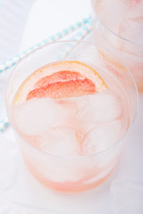 Juicy grapefruit cocktail with ice and alcohol, selective focus