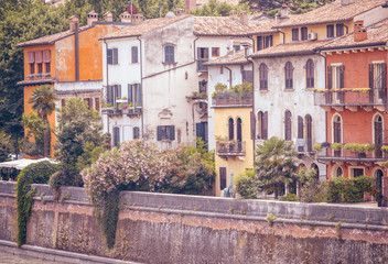 Fototapeta na wymiar Italian style buildings and gardens on a bank of Adige river in Verona, Italy.