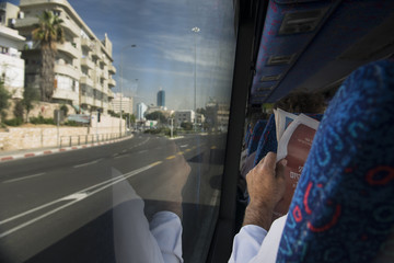 Israel. Jewish man reading newspaper going by bus.