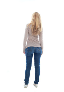 beautiful young woman with long blonde hair wearing a long sleeved cream shirt and gold necklace. standing pose, isolated on white background.