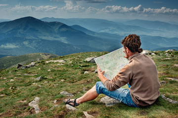 tourist in mountains examines map