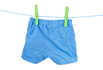 blue children's shorts on the clothesline on a white background