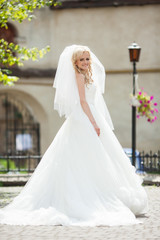 elegant stylish gorgeous blonde bride on the background old city