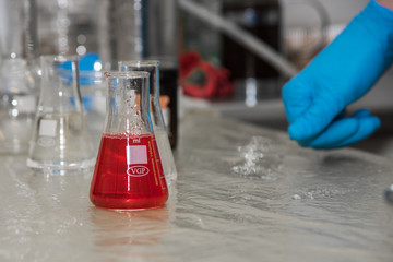 Flask in scientist hand with Test tubes