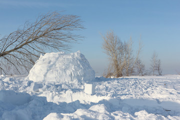 Construction an igloo  on a snow glade in the winter