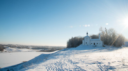 Fototapeta premium Church on the hill in background of a winter landscape