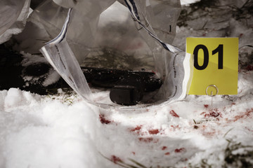 Obraz na płótnie Canvas Investigation of murder on snow - pistol found