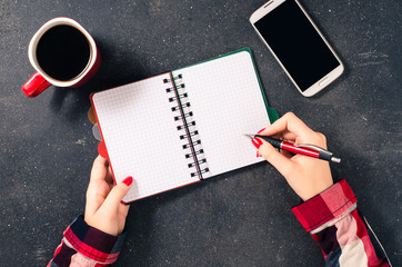 Female hands writing in empty notebook