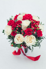 Fototapeta na wymiar Wedding bouquet of white and red roses in fresh snow