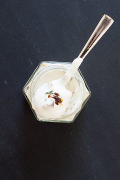 Teaspoon with greek yogurt with marinated dried tomatoes and thyme . Selective focus.