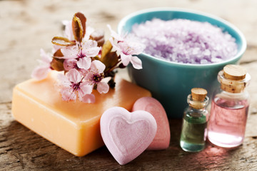 Fototapeta na wymiar Spa setting with soap, bath salt, essential oils and flowers