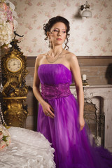 Beautiful  woman dressed in long lace dress in a vintage interio
