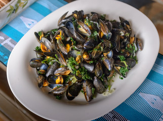 Boiled mussels in a cooking dish on a on table. Selective focus