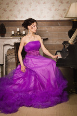 Woman dressed in long lace dress playing piano
