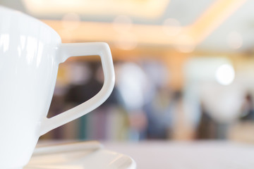 Focus on the white tea cup with blurred background of conference