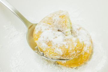 Icing sugar on Donuts in spoon