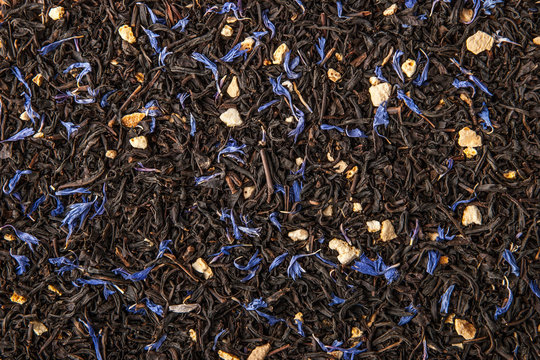 Tea with  dried orange and cornflower petals background