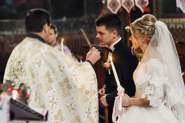 Emotional blonde bride in vintage white dress and handsome groom