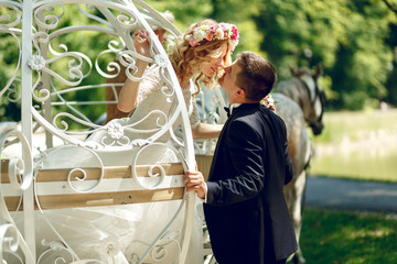 Romantic fairy-tale wedding couple bride and groom kissing in ma