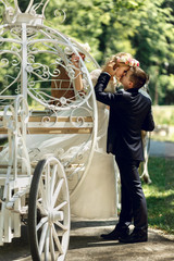 Romantic fairy-tale wedding couple bride and groom kissing in ma