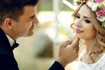 Handsome groom sensual touching emotional happy blonde bride in