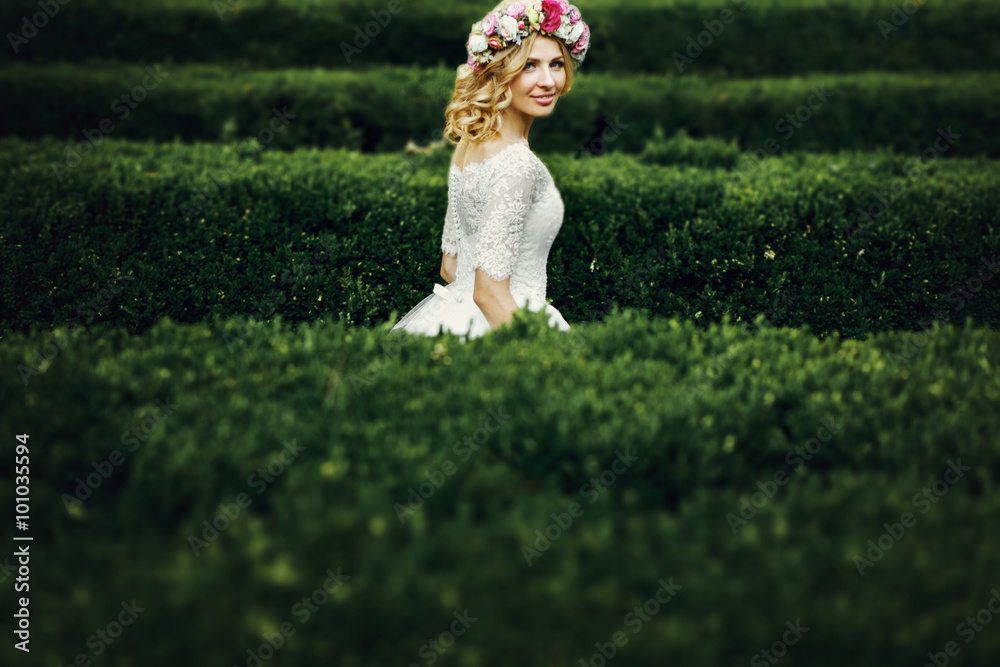 Wall mural magical beautiful young blonde bride in elegant dress walking in