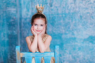 Girl dressed as princess with a crown looking at the camera